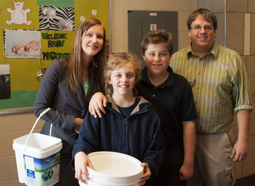 St. Ann Catholic School "Battery Lead" students Blain and Schuyler pose for a picture with Sarah Lacharity of Raw Materials Company and Mr. Kuczera of St. Ann Catholic School 